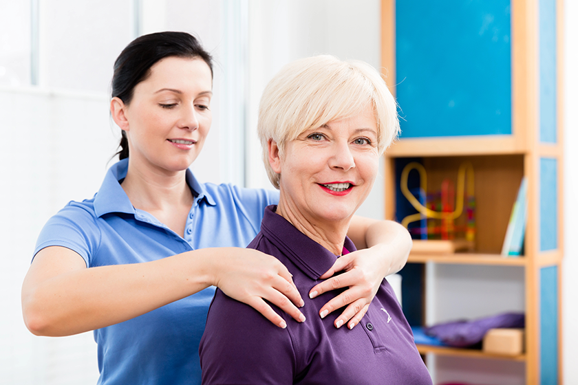 Masseuse applying neck massage on older woman 