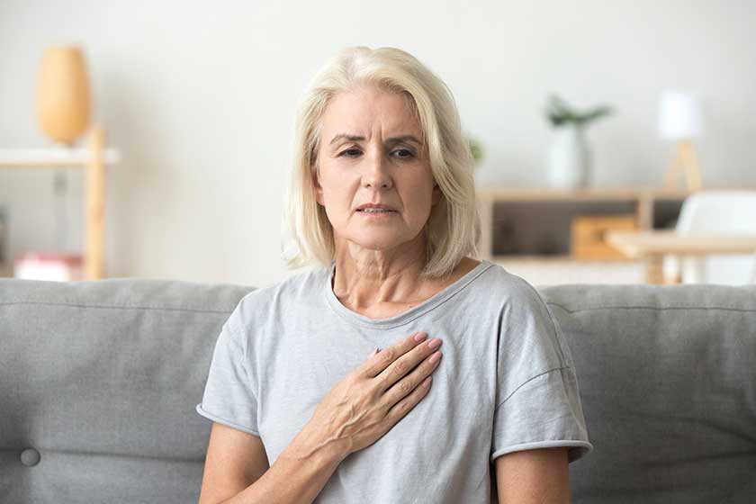 Upset stressed mature older woman feeling heartache touching chest